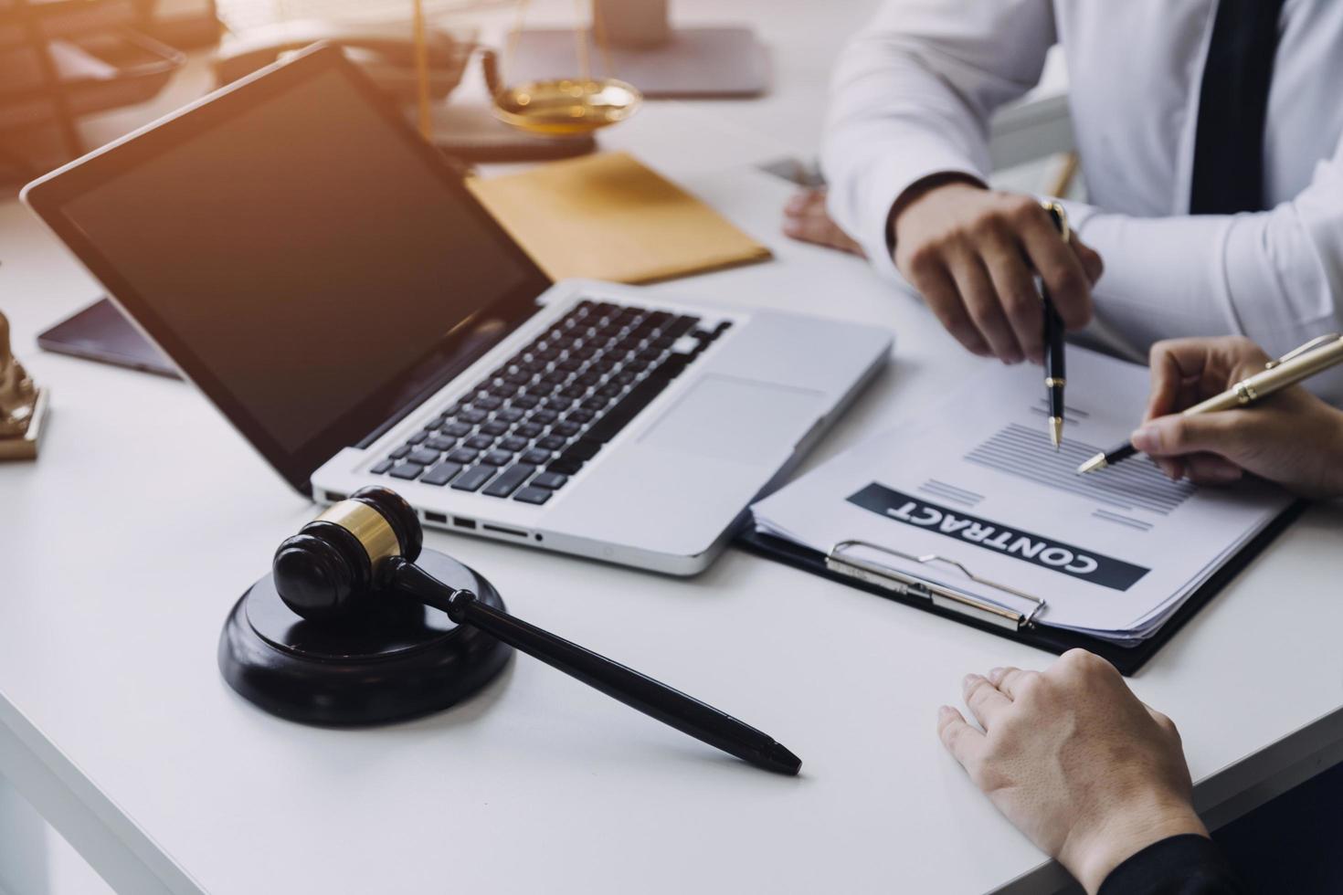 abogado masculino que trabaja con papeles de contrato y mazo de madera en tabel en la sala del