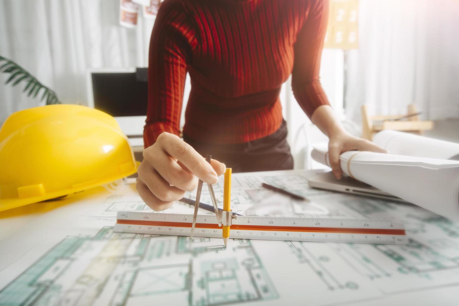 Two colleagues discussing data working and tablet, laptop with on on architectural project at construction site at desk in office photo