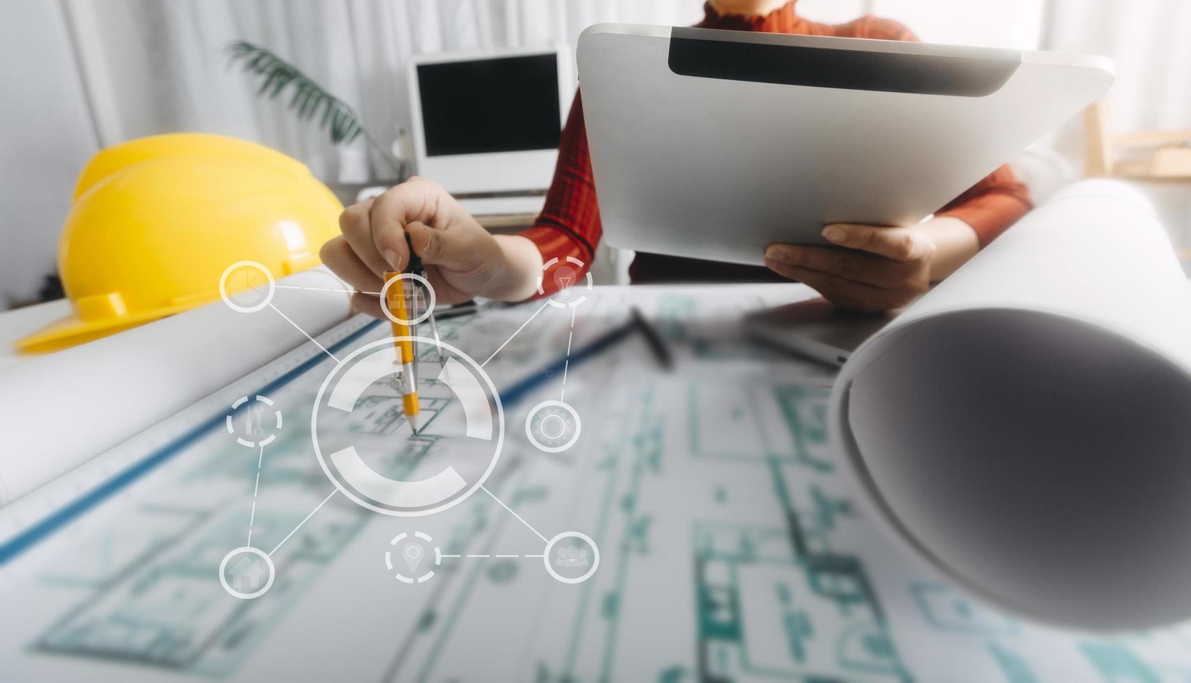 Two colleagues discussing data working and tablet, laptop with on on architectural project at construction site at desk in office photo