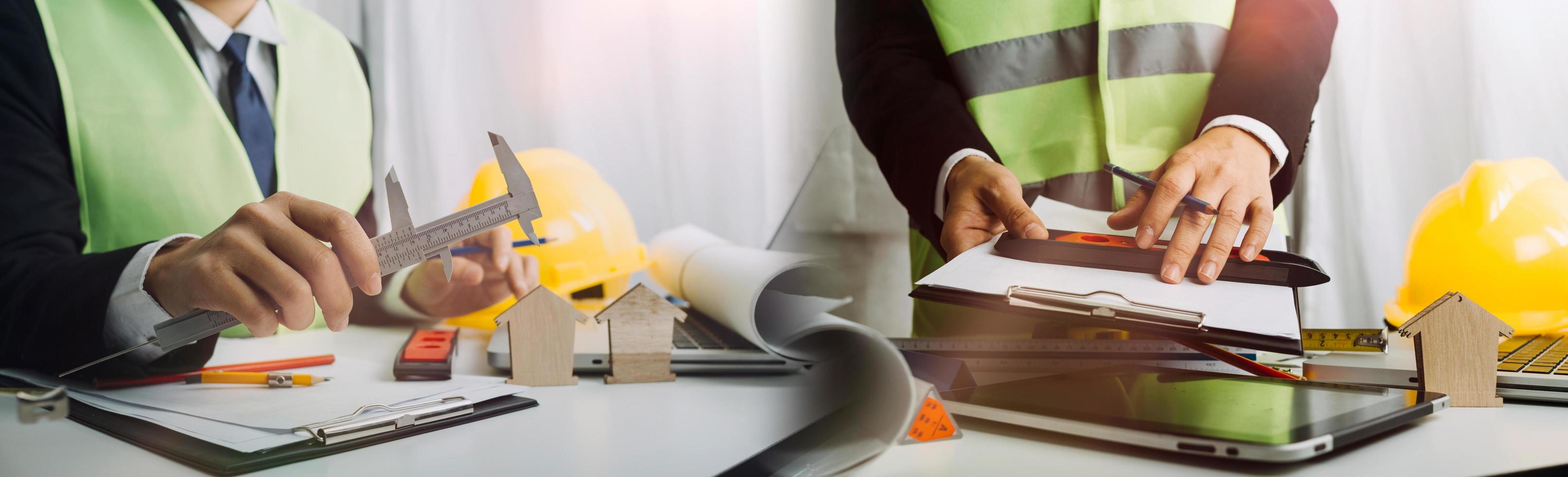 business hand working and laptop with on on architectural project at construction site at office desk in office photo