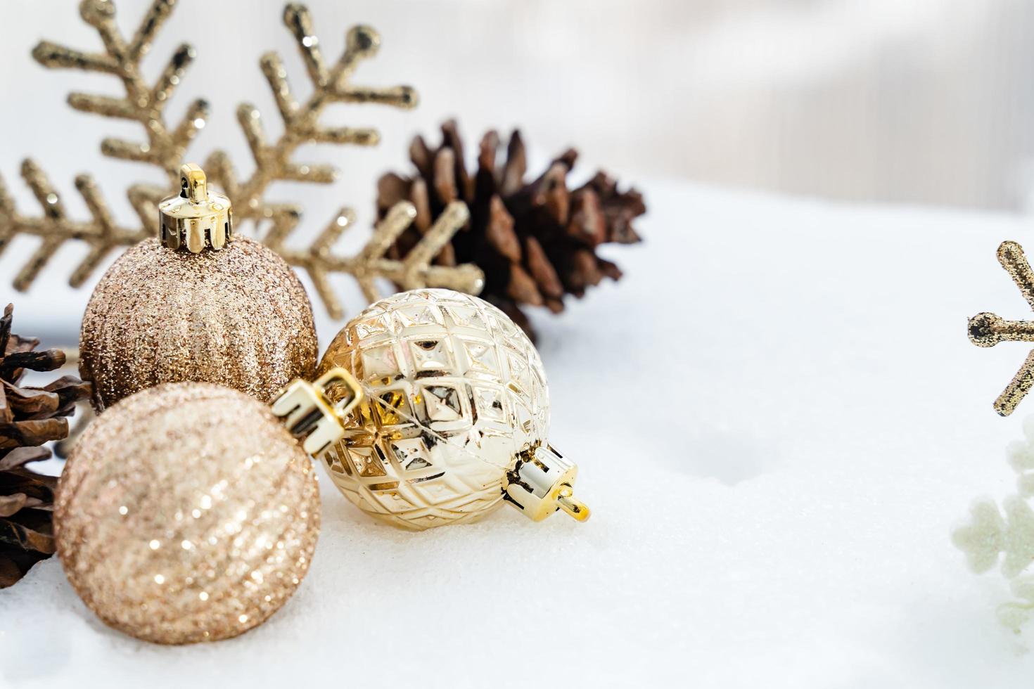 navidad de invierno - bolas de navidad con cinta en la nieve, concepto de vacaciones de invierno. bolas rojas de navidad, bolas doradas, decoraciones de pino y copos de nieve en el fondo de la nieve foto