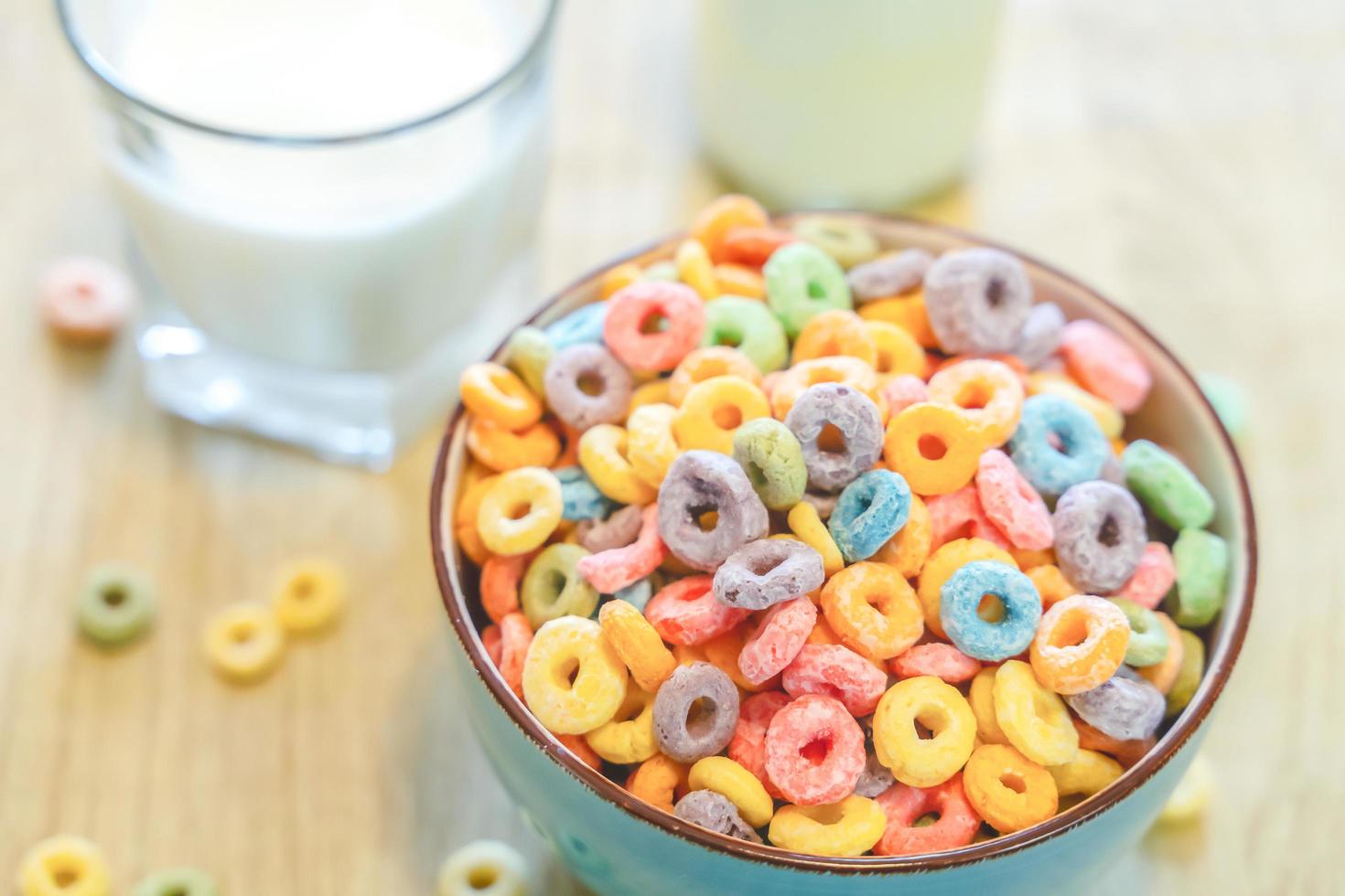 Bowl of colorful children's cereal and milk isolated on wood table with Text space photo