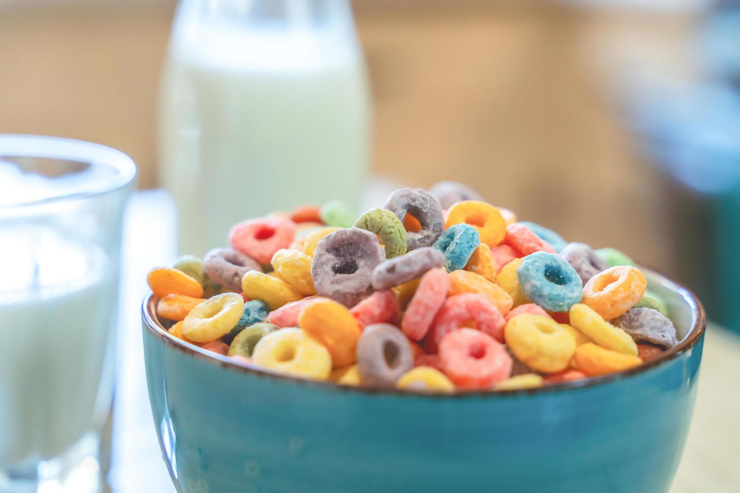 Bowl of colorful children's cereal and milk isolated on wood table with Text space photo