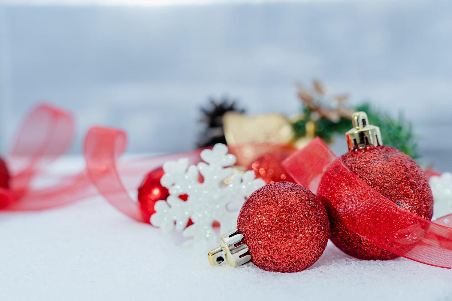 Christmas of  winter - Christmas balls with ribbon on snow, Winter holidays concept. Christmas red balls, golden balls, pine And Snowflakes decorations In Snow Background photo