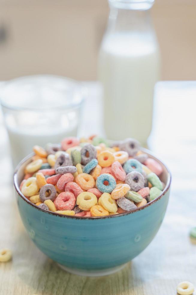 Bowl of colorful children's cereal and milk isolated on wood table with Text space photo