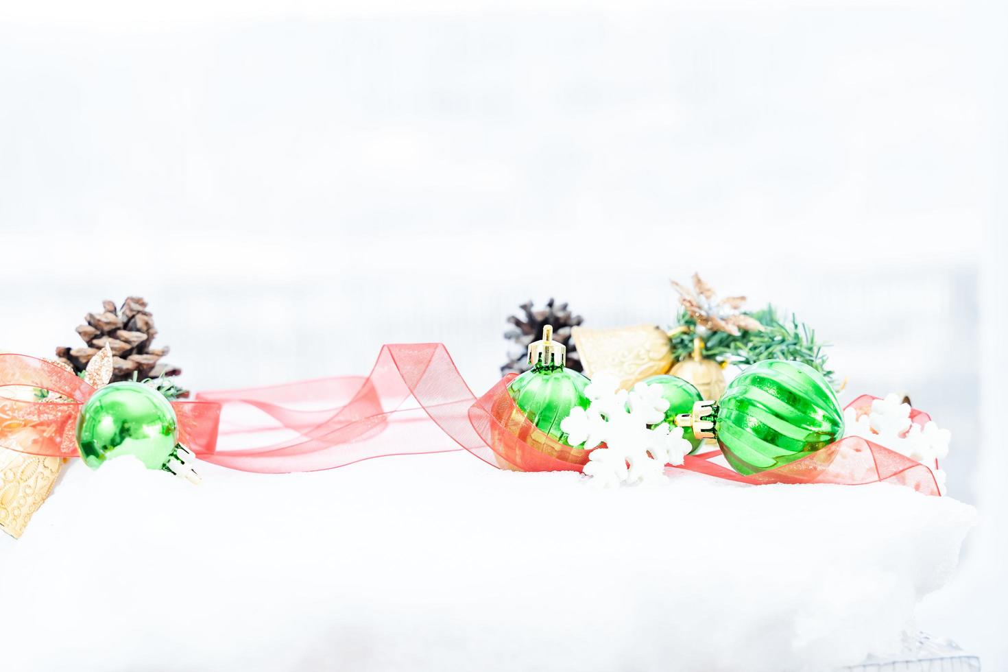 Christmas of  winter - Christmas balls with ribbon on snow, Winter holidays concept. Christmas green balls, golden balls, pine And Snowflakes decorations In Snow Background photo