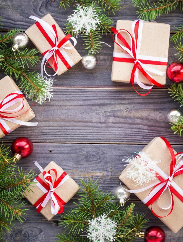 Christmas background with fir tree and decorations and gift boxes on wooden board photo