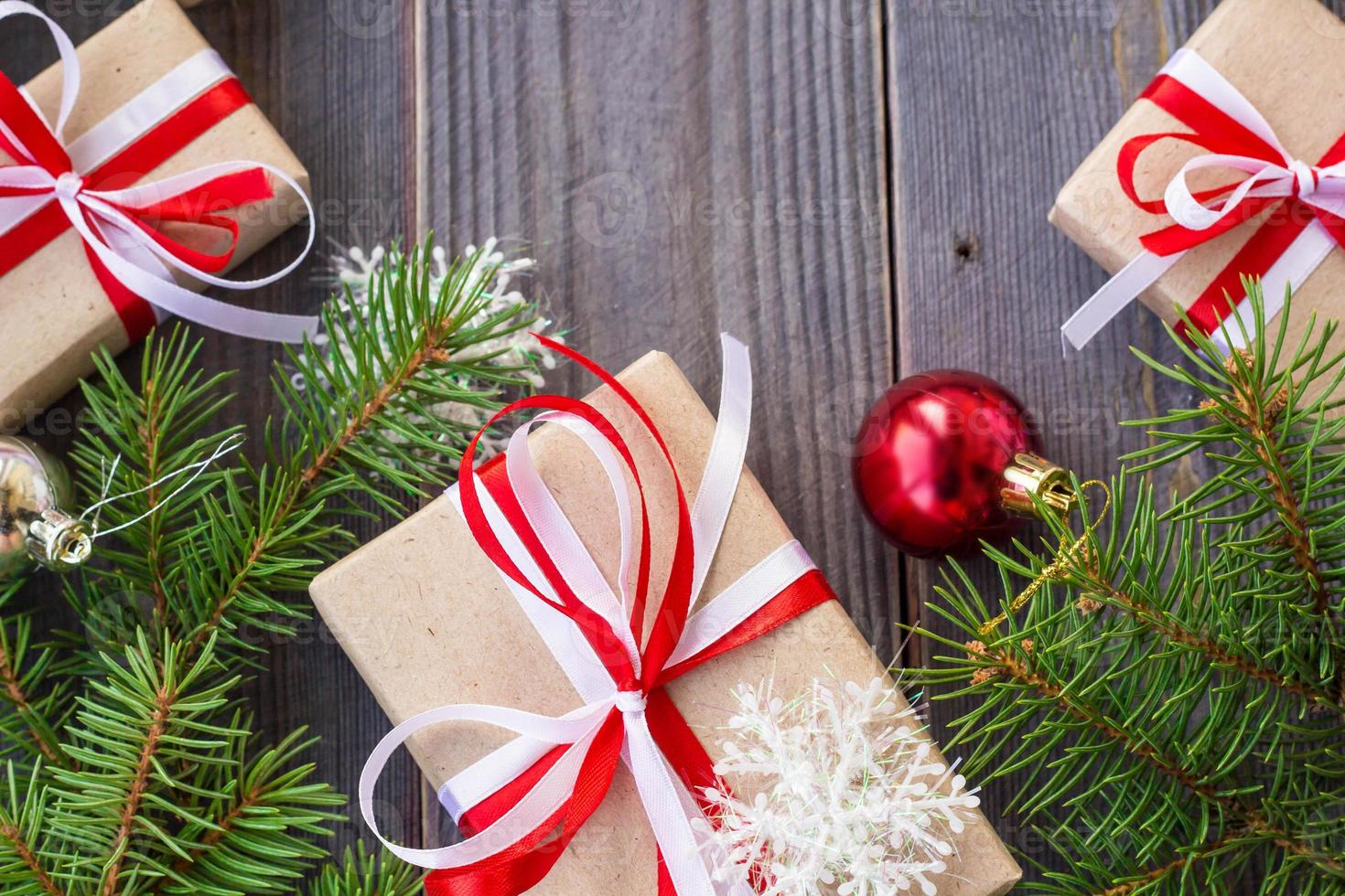 Christmas background with fir tree and decorations and gift boxes on wooden board photo