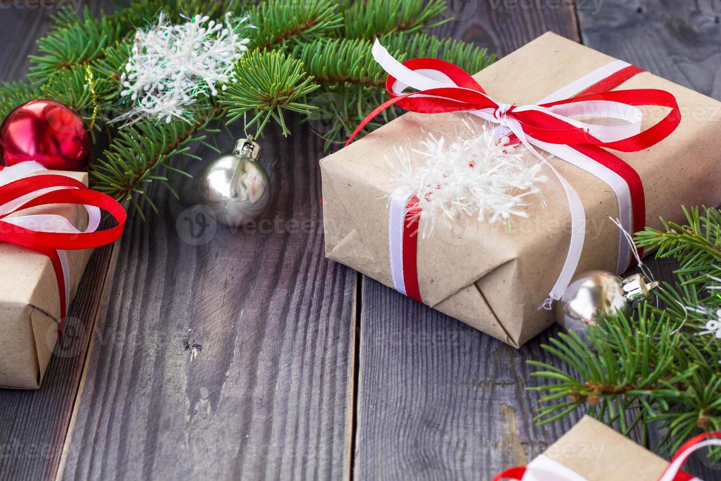 Christmas background with fir tree and decorations and gift boxes on wooden board photo