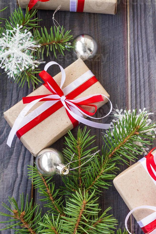 Christmas background with fir tree and decorations and gift boxes on wooden board photo