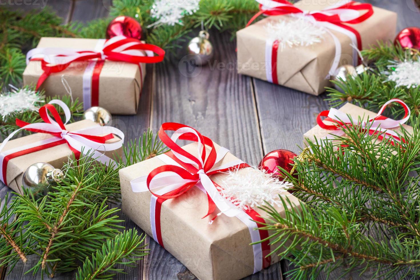 Christmas background with fir tree and decorations and gift boxes on wooden board photo