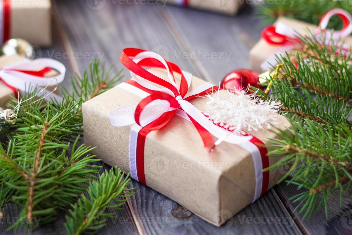 Christmas background with fir tree and decorations and gift boxes on wooden board photo