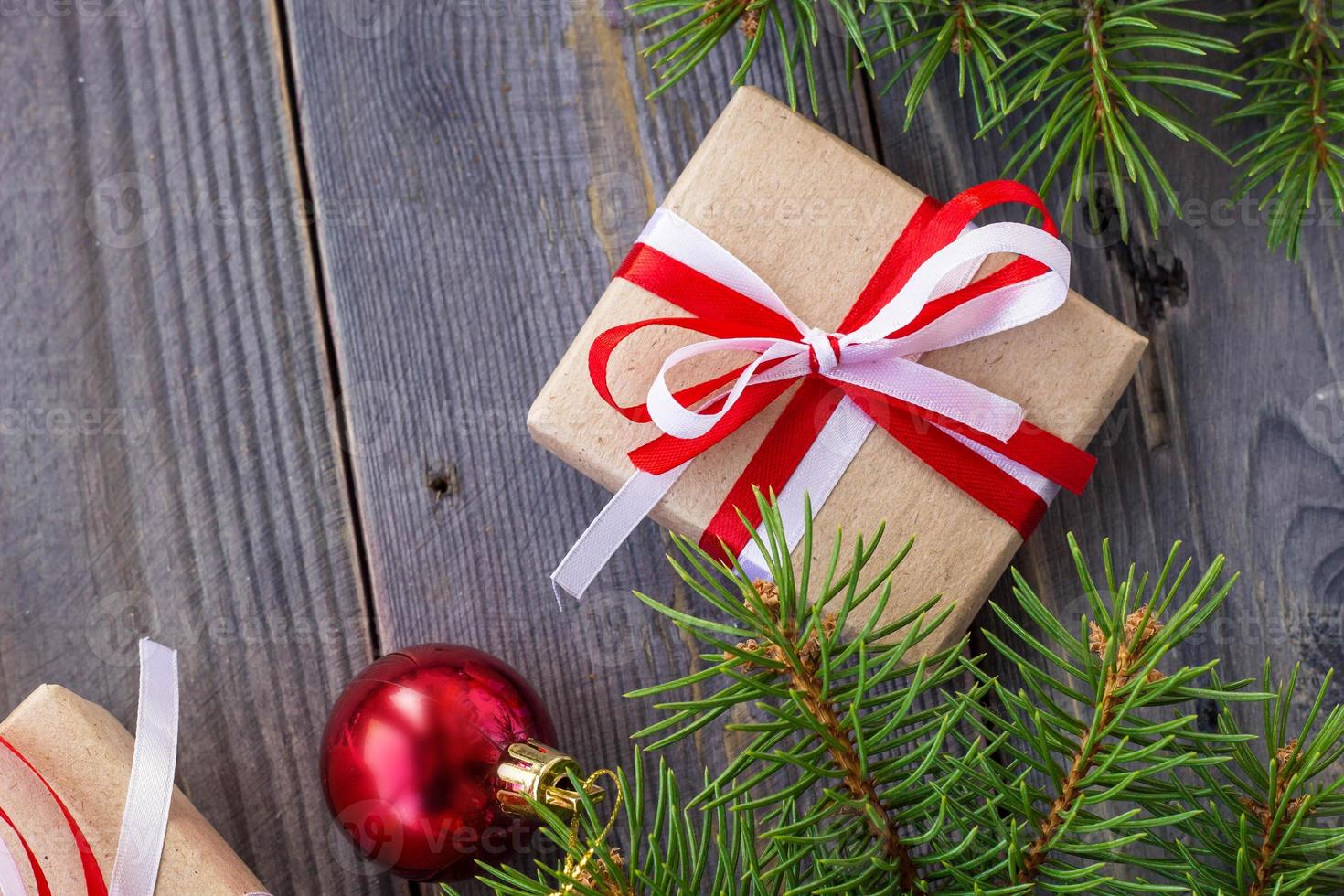 Christmas background with fir tree and decorations and gift boxes on wooden board photo