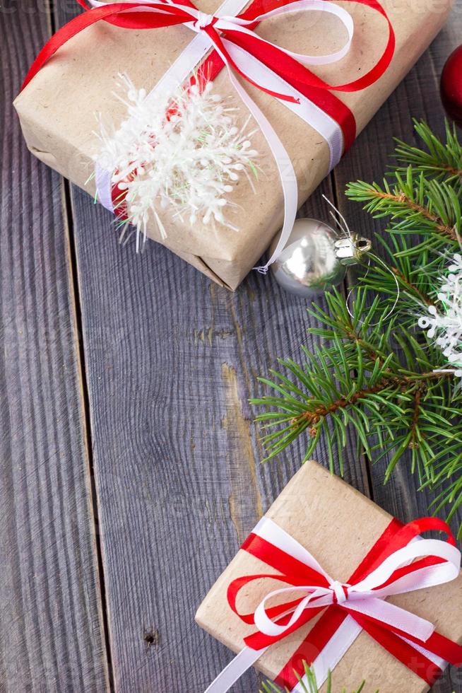 Christmas background with fir tree and decorations and gift boxes on wooden board photo