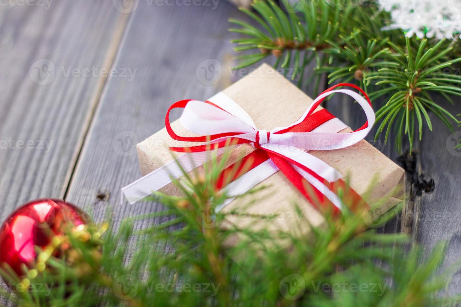 Christmas background with fir tree and decorations and gift boxes on wooden board photo