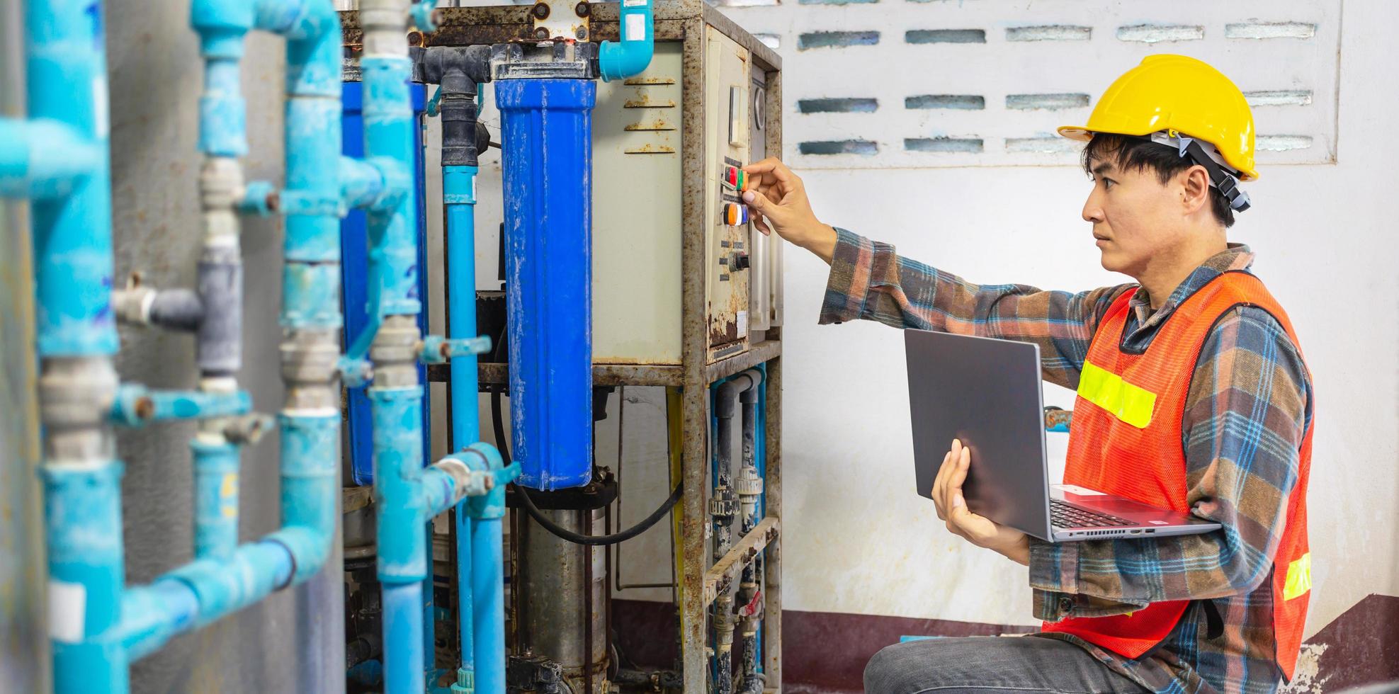 Engineer working in drinking water factory using a tablet computer to check water management system and boiler water pipe in water factory photo