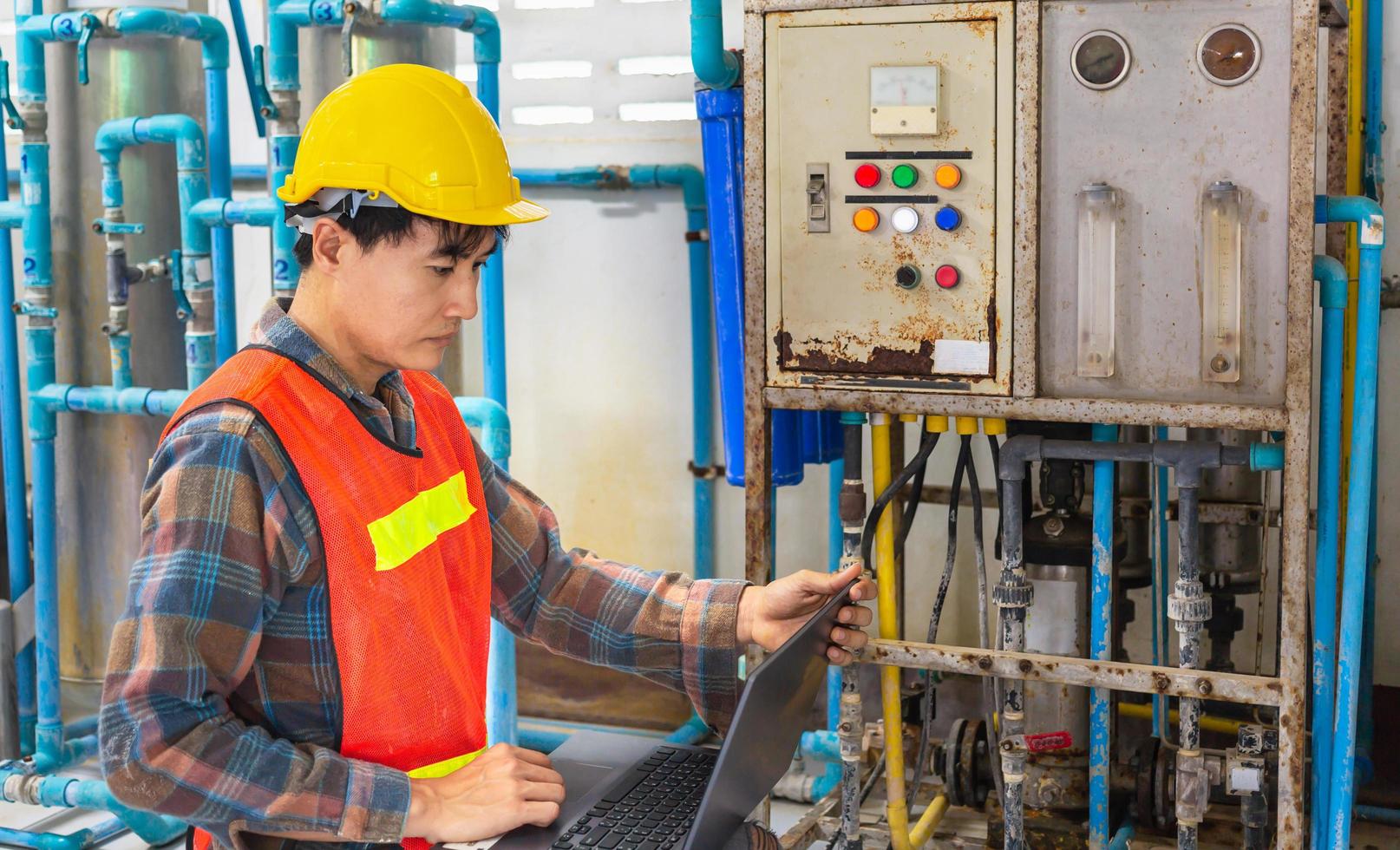 ingeniero que trabaja en una fábrica de agua potable usando una tableta para verificar el sistema de gestión del agua y la tubería de agua de la caldera en la fábrica de agua foto