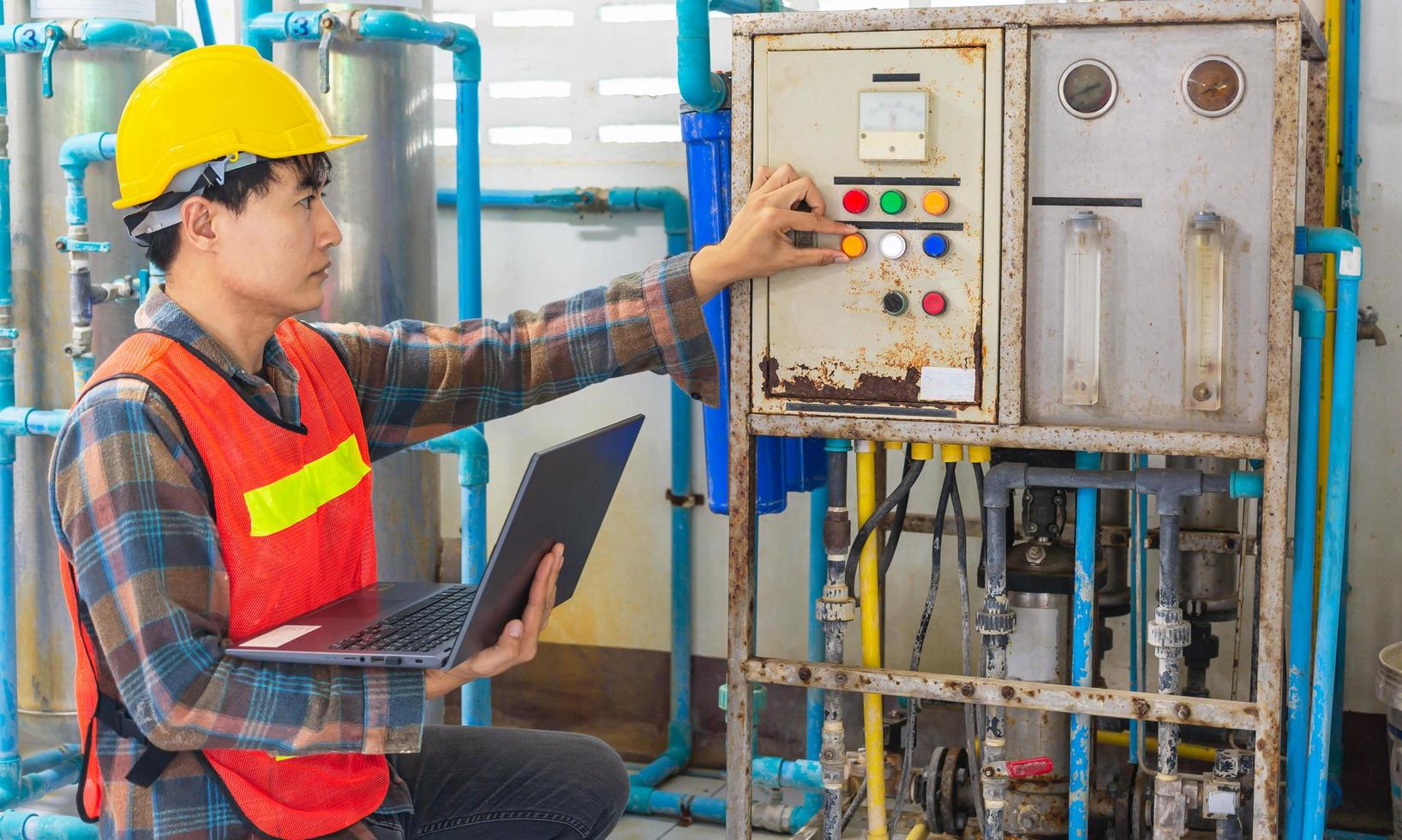 Engineer working in drinking water factory using a tablet computer to check water management system and boiler water pipe in water factory photo