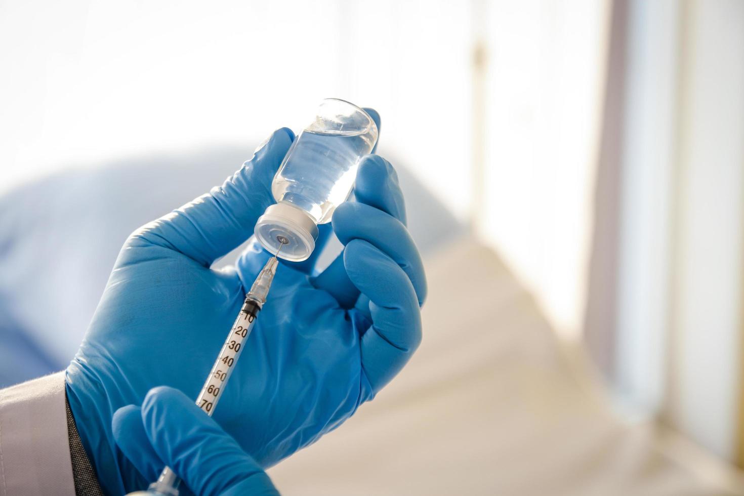 Doctor holding coronavirus vaccine needle. The concept of providing medical services to prevent the spread of the virus. photo