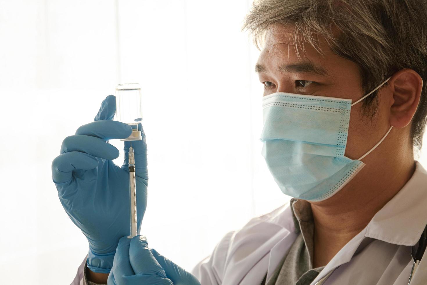 Doctor holding coronavirus vaccine needle. The concept of providing medical services to prevent the spread of the virus. photo