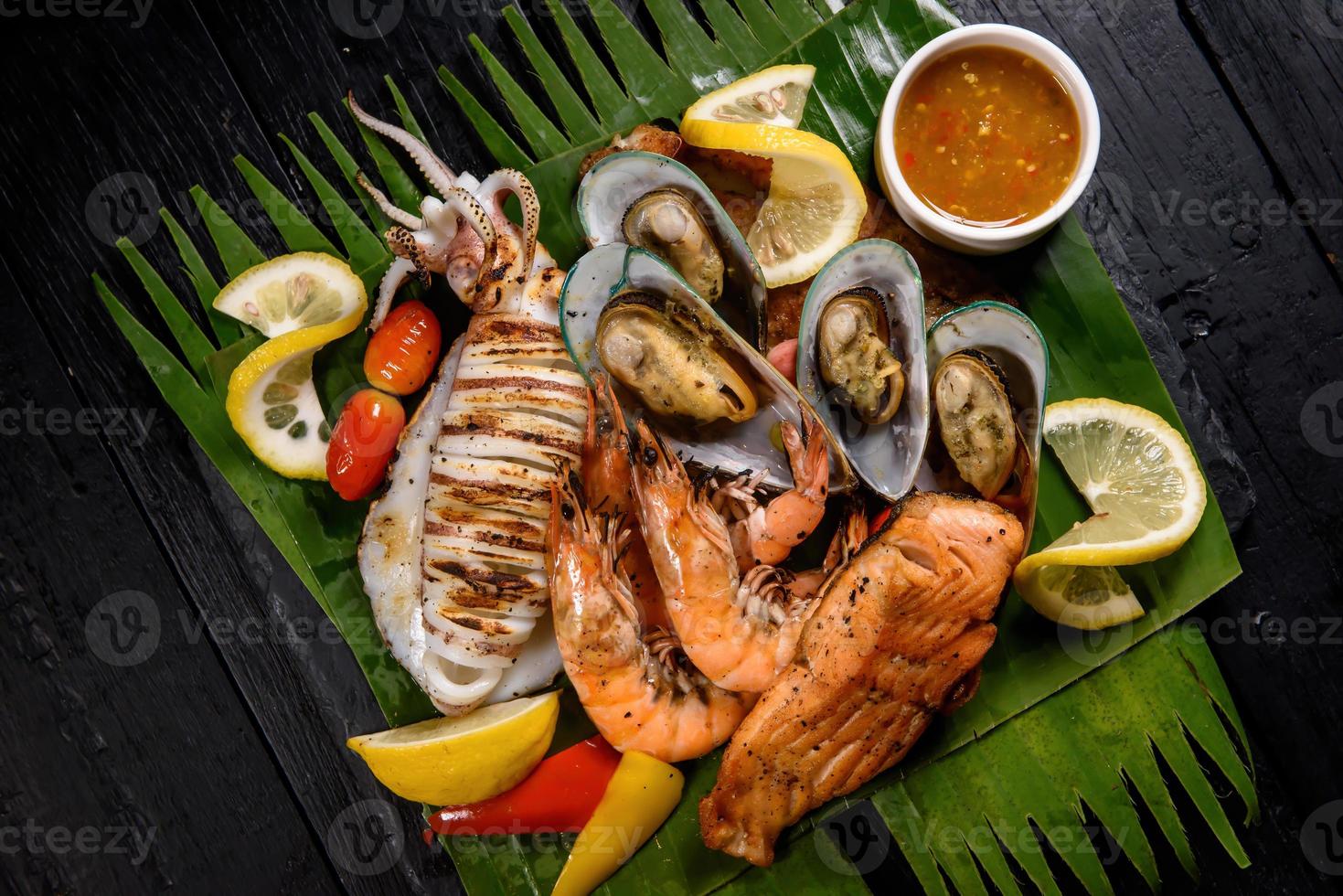 Parrillada mixta de mariscos que incluye cangrejo azul, mejillones, camarones grandes, calamares y salmón a la parrilla foto