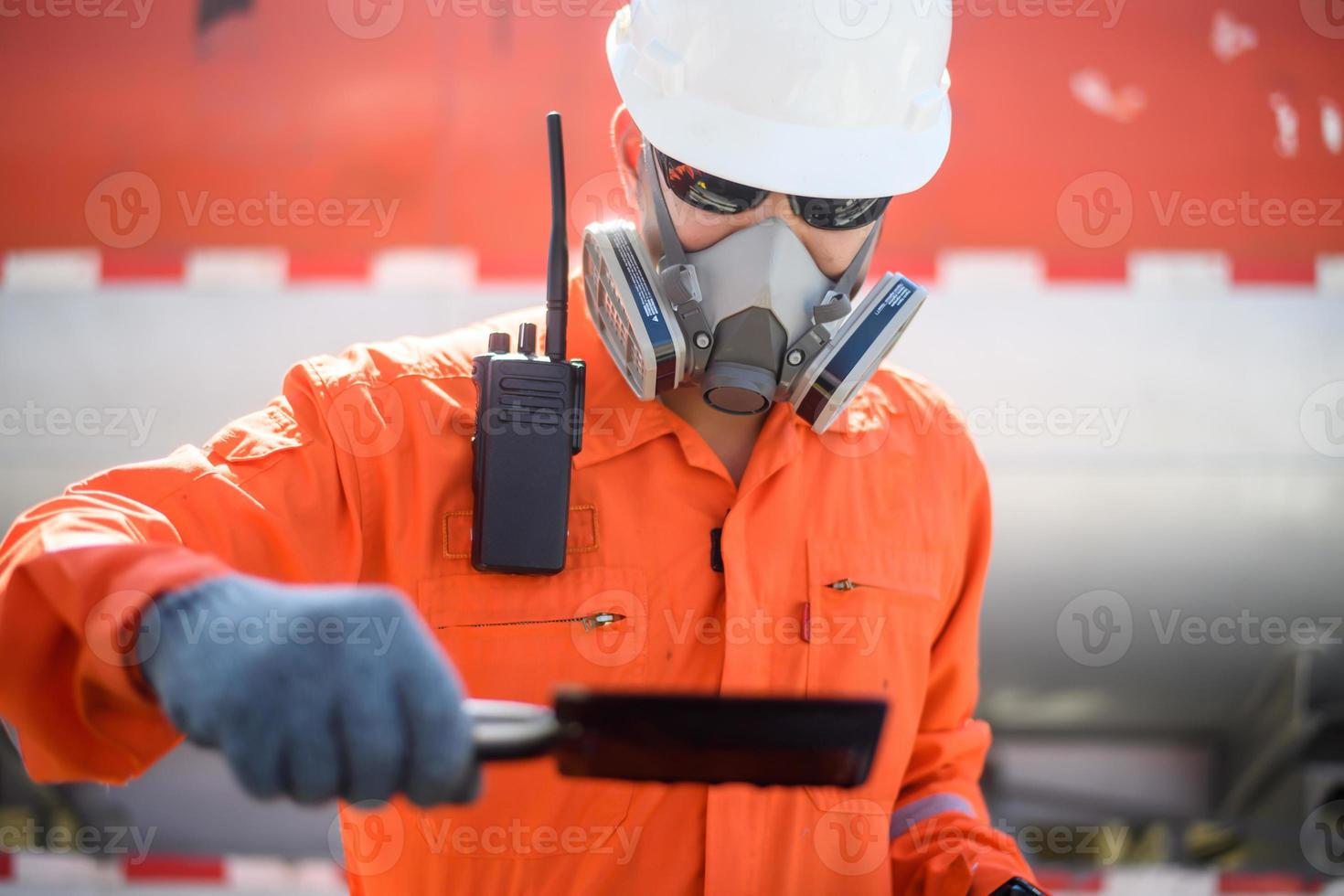 un hombre que trabaja en un campo petrolero o en una plataforma petrolera y está revisando o inspeccionando el aceite. foto