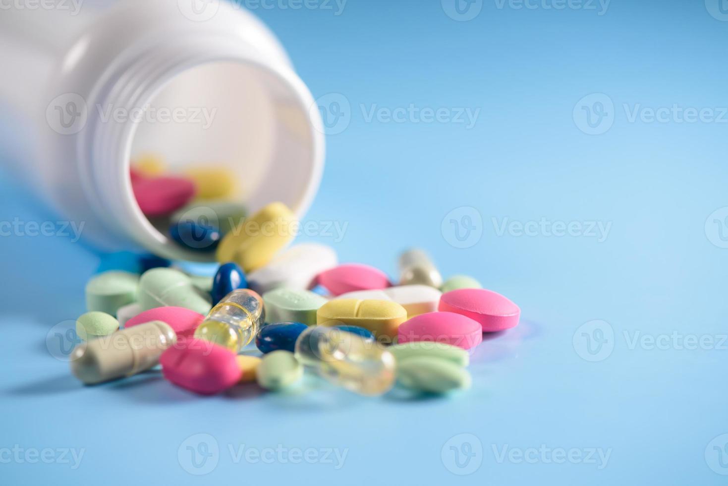 pills with bottle isolated on blue background photo