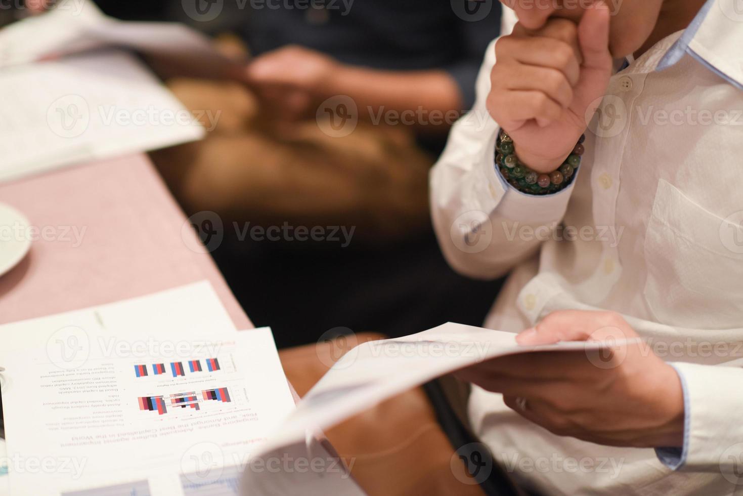 Close-up Of Businessman Holding Document At Desk photo