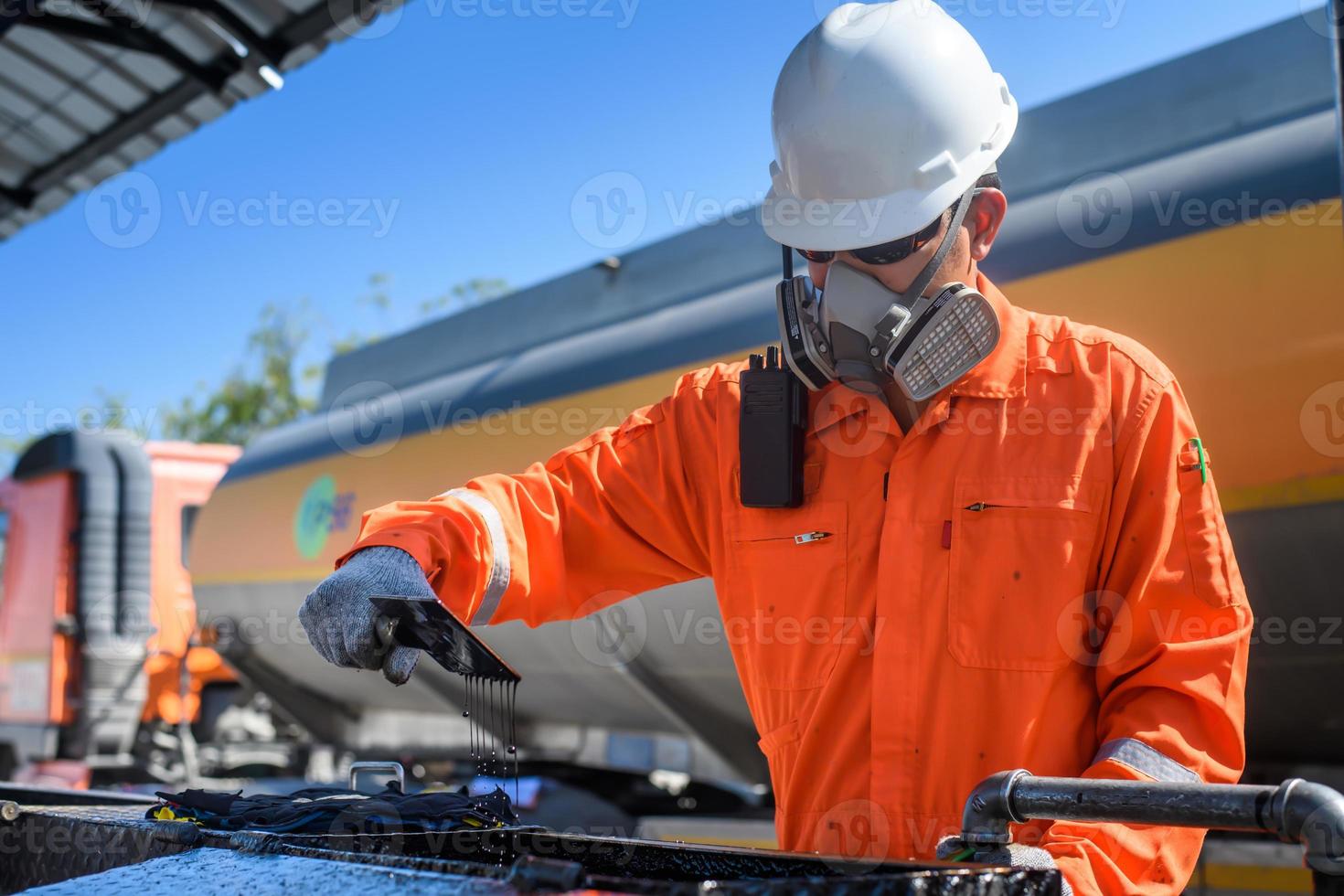 a man working in an oil field and he's checking or  inspecting the oil. photo