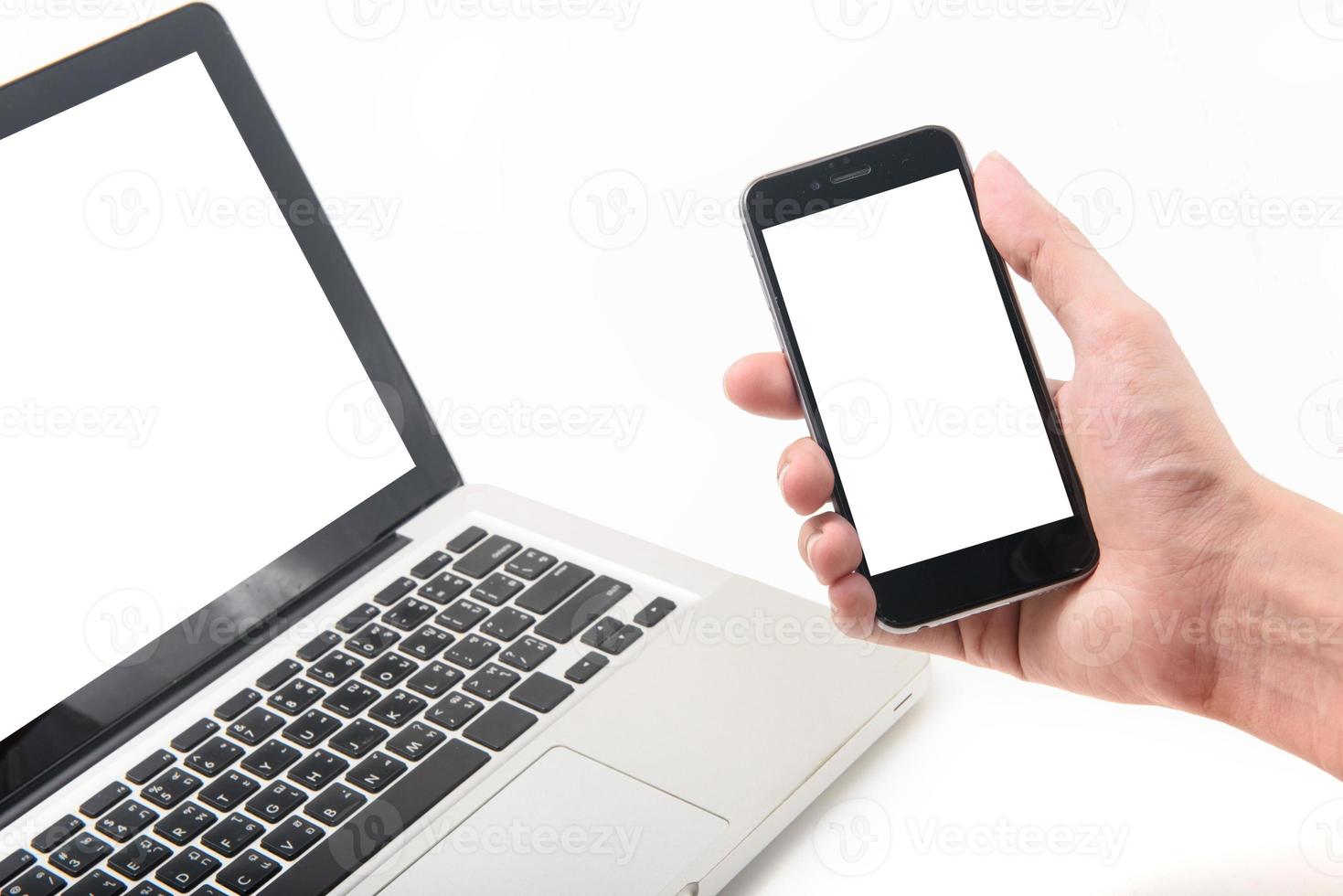 Laptop and smartphone mockup. Closeup of man holding in hand. photo