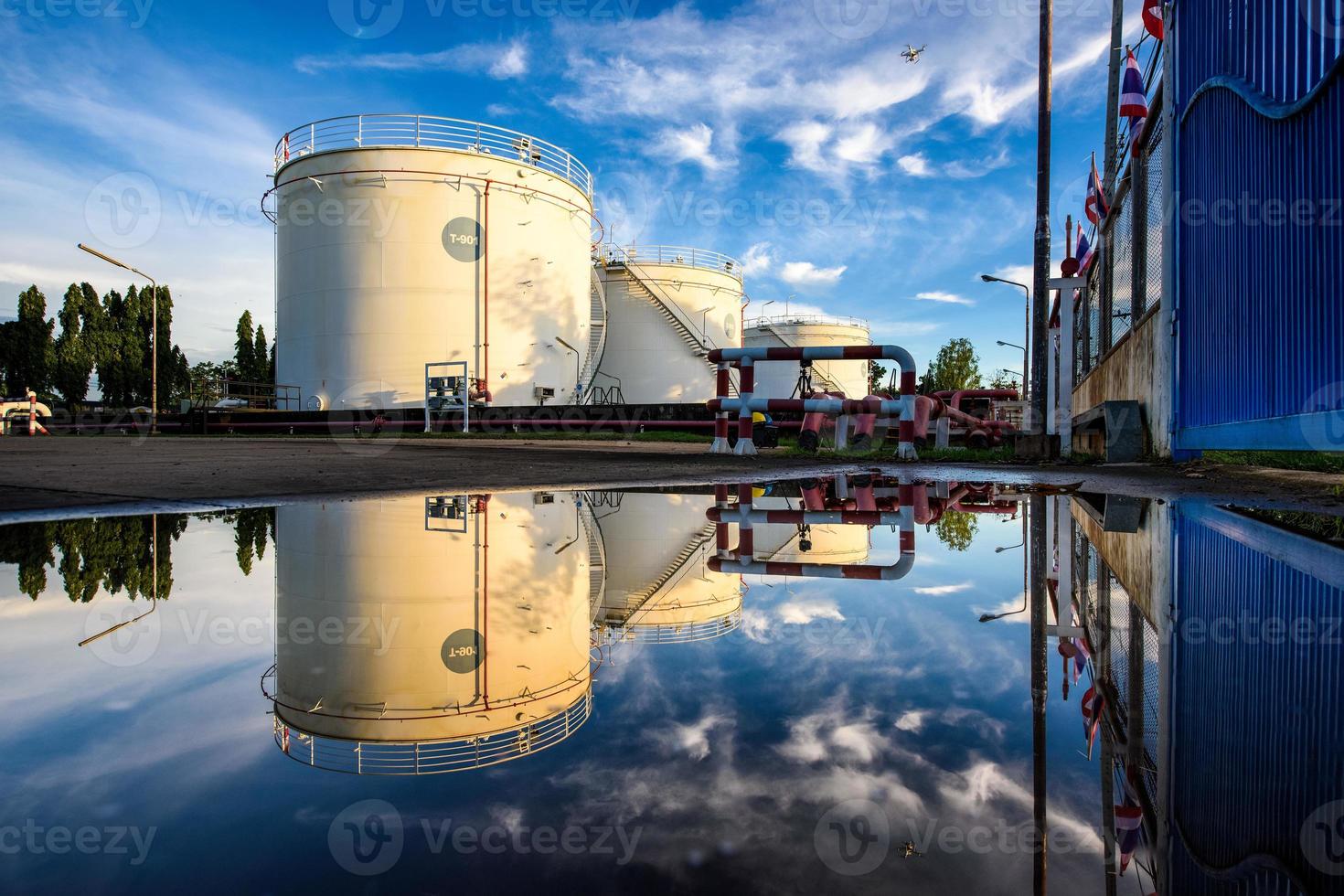 gran tanque de aceite industrial que refleja agua en la planta industrial de base de refinería foto