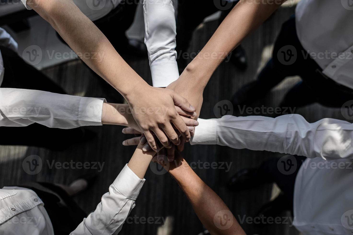 Close up of young businessmen put their hands together. Stack of hands concept of unity and teamwork. photo