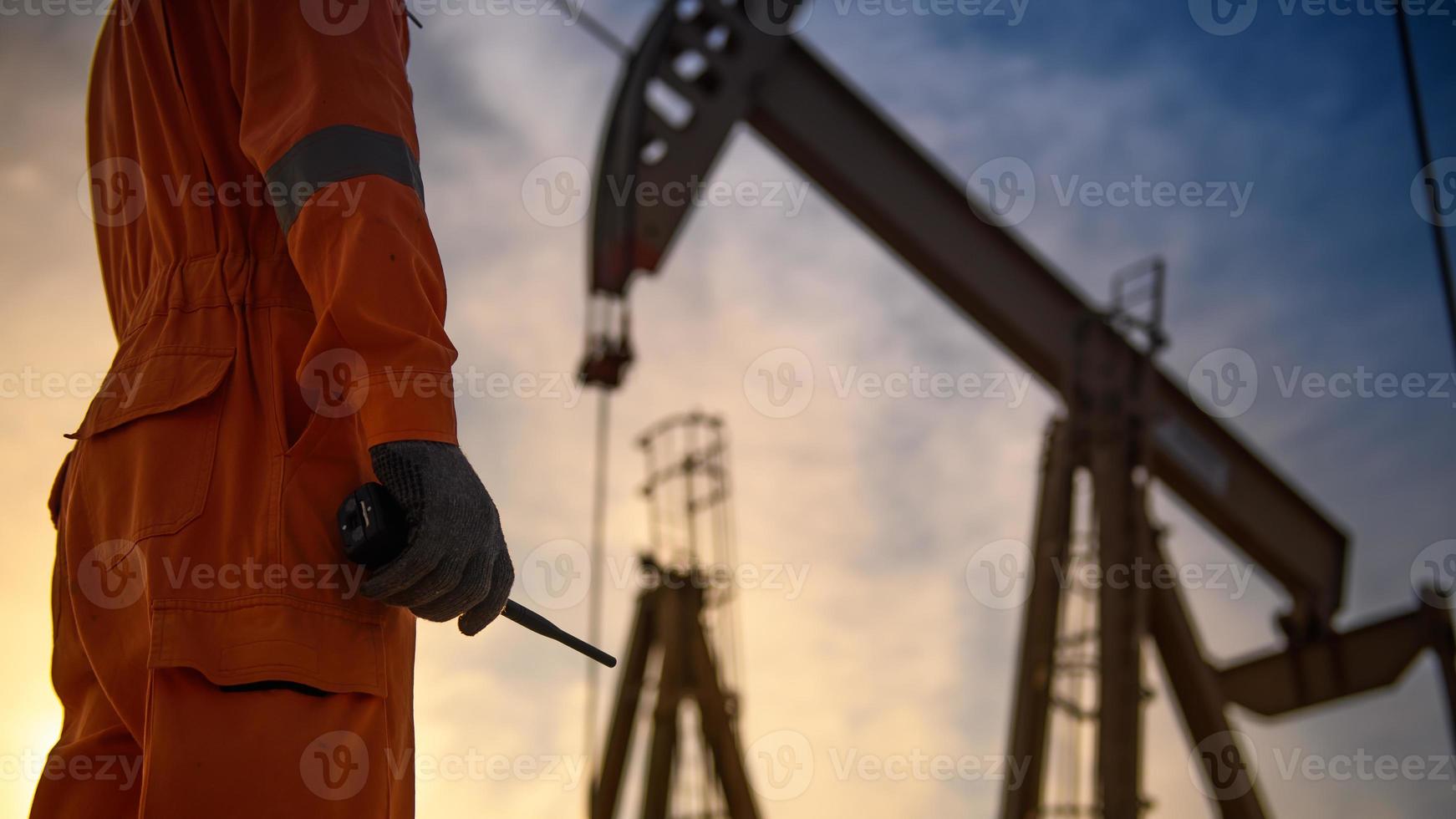 Silhouette of oil workers working in the evening and beautiful sunset. photo