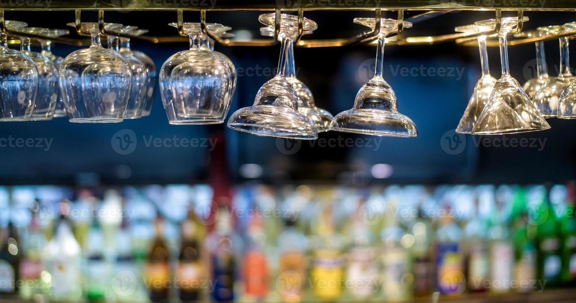 Glasses hanging over a bar rack in the hotel restaurant. photo