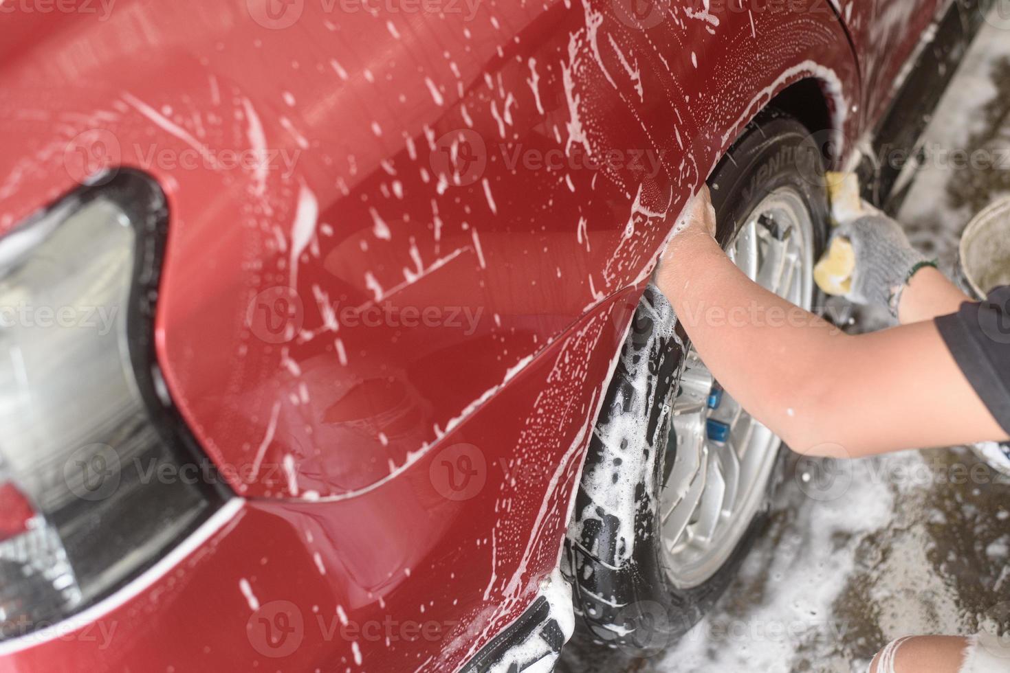 hand hold sponge over the wheel car for washing photo