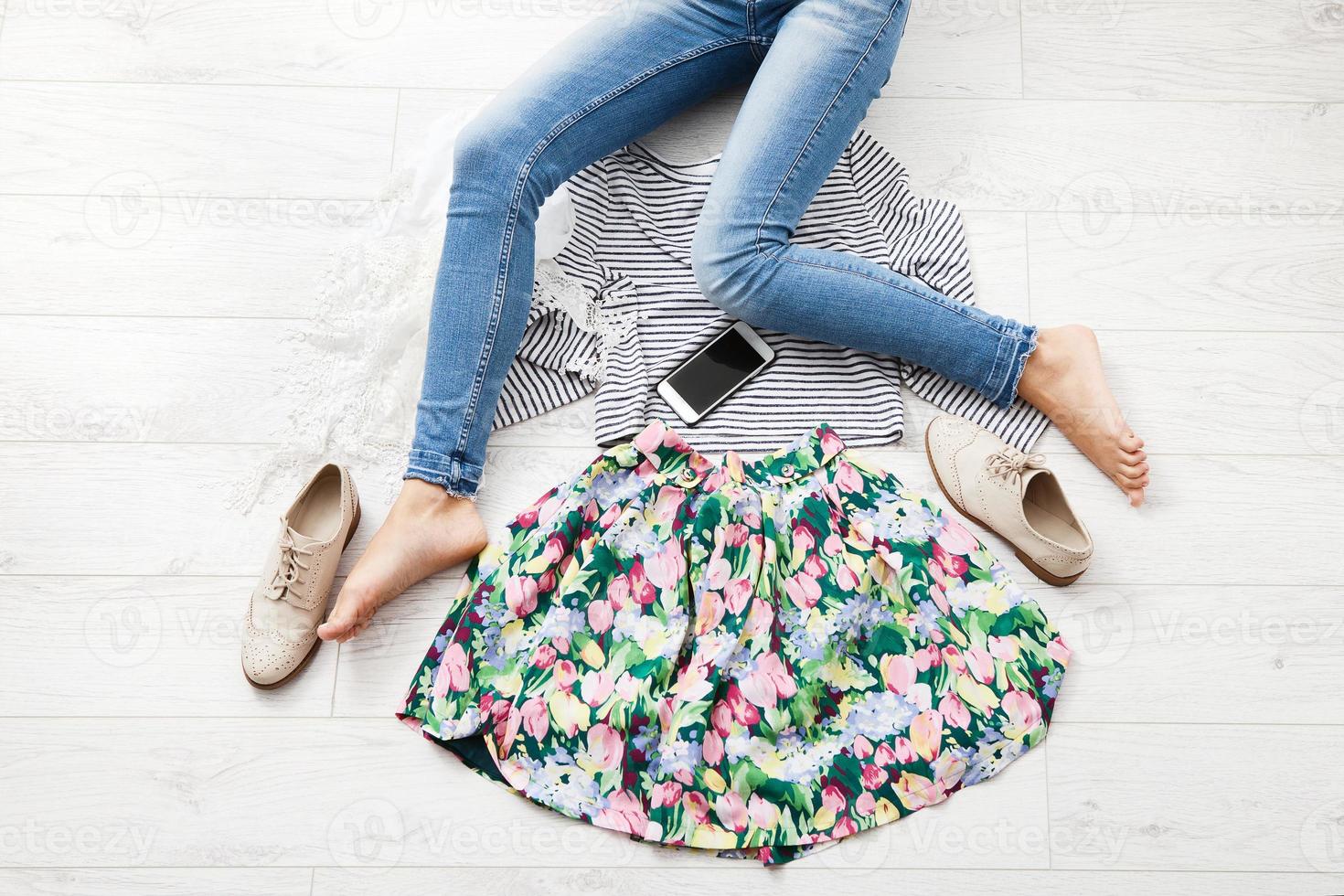 Stylish outfit with accessories and female legs on white wooden background. Top view and copy space photo