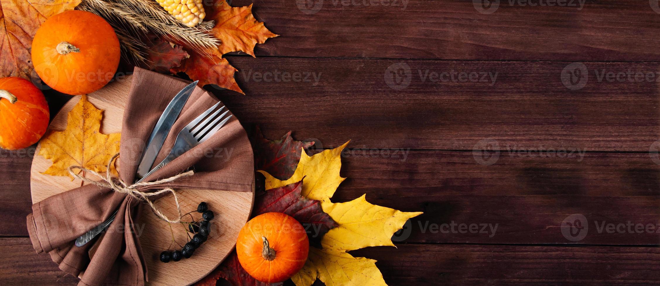 Thanksgiving cutlery setting. Festive table decor on wooden background. photo