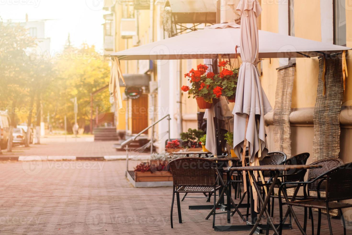 café de la calle en el casco antiguo. mesas y sillas vacías. vista de la ciudad de otoño. estilo vintage, colores neutros de moda. foto