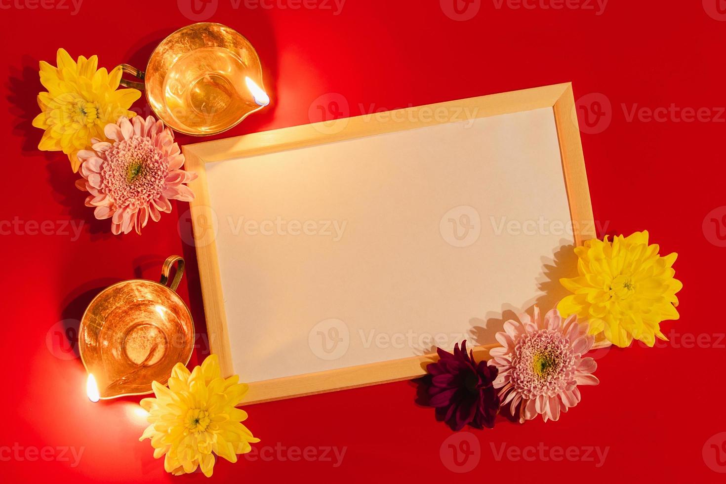 Happy Diwali. Diya oil lamp and flowers on red background. Celebrating the Indian traditional festival of light. photo