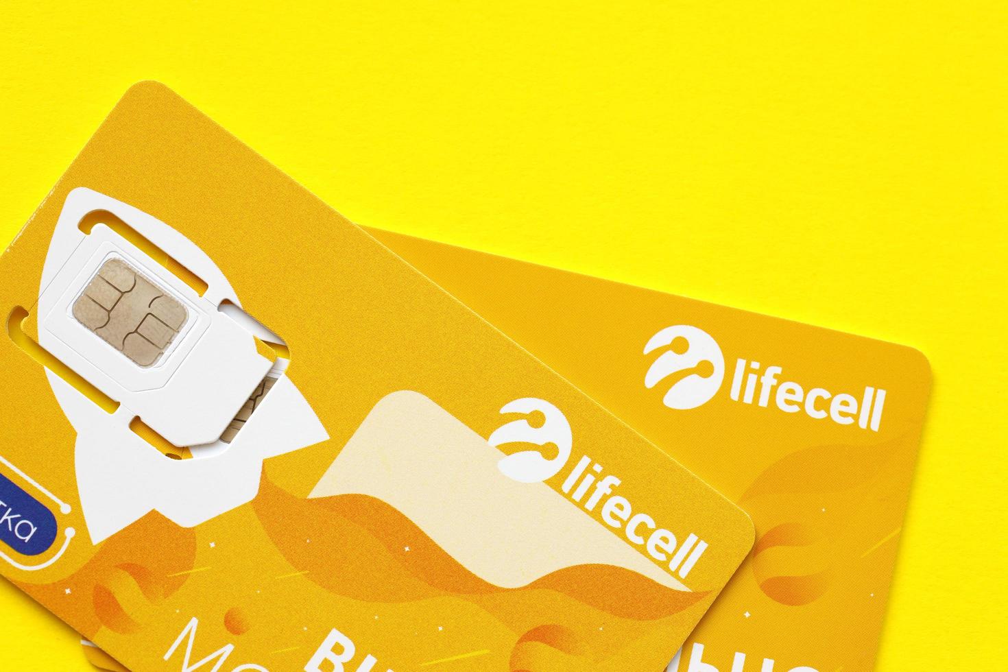 TERNOPIL, UKRAINE - JULY 5, 2022 Lifecell new sim card with free contract on yellow background. Lifecell is ukrainian mobile telephone network operator and provider of wireless connection photo