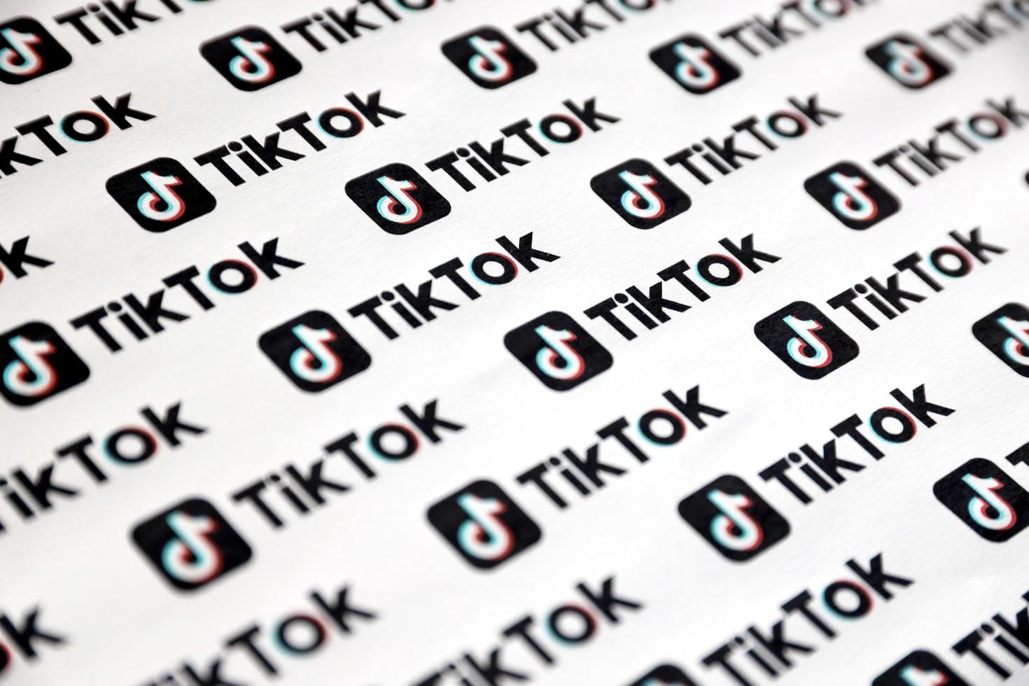 TERNOPIL, UKRAINE - MAY 2, 2022 Many TikTok logo printed on paper. Tiktok or Douyin is a famous Chinese short-form video hosting service owned by ByteDance photo