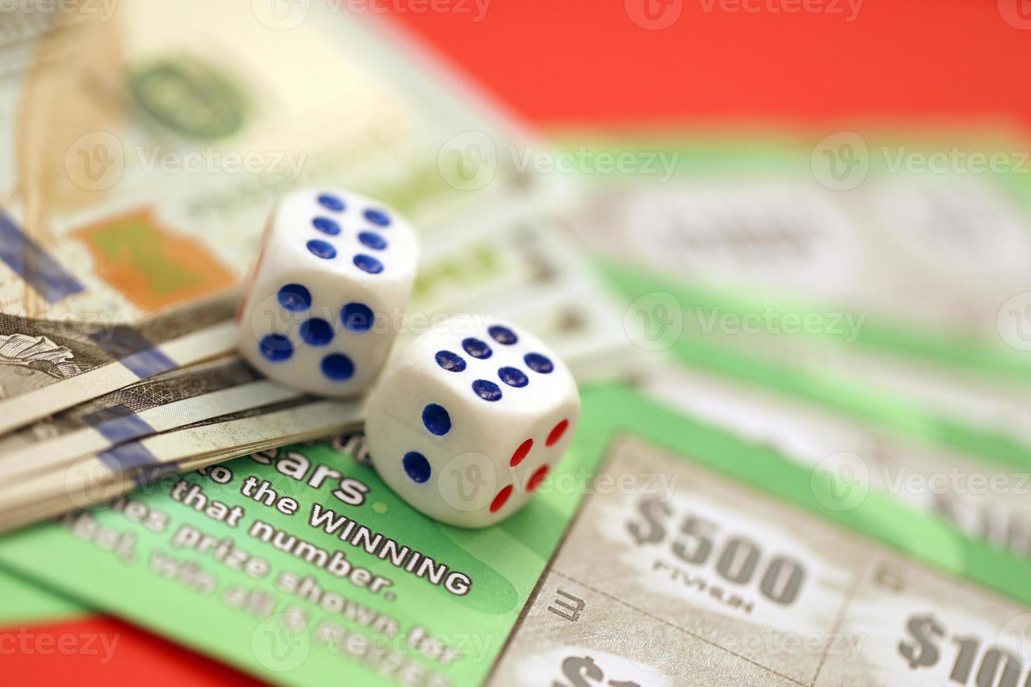 Close up view of green lottery scratch cards with us dollar bills and dice. Many used fake instant lottery tickets with gaming results photo