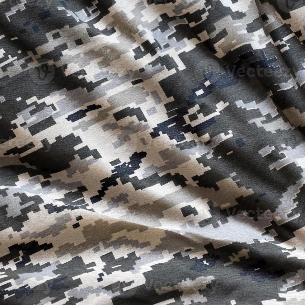 Fabric with texture of Ukrainian military pixeled camouflage. Cloth with camo pattern in grey, brown and green pixel shapes. Official uniform of Ukrainian soldiers photo