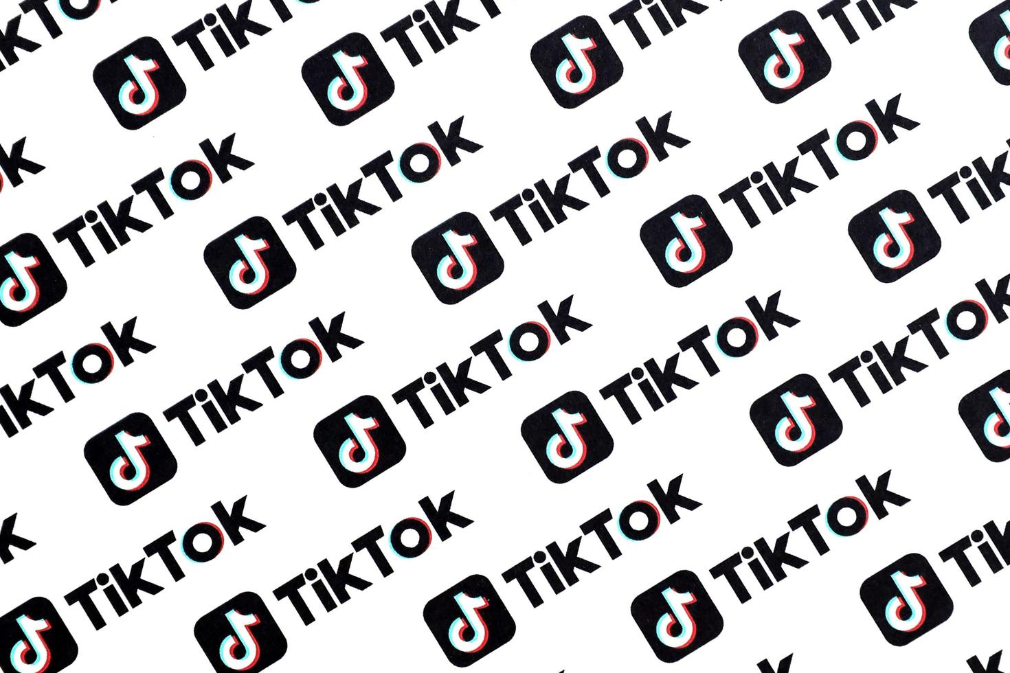 TERNOPIL, UKRAINE - MAY 2, 2022 Many TikTok logo printed on paper. Tiktok or Douyin is a famous Chinese short-form video hosting service owned by ByteDance photo