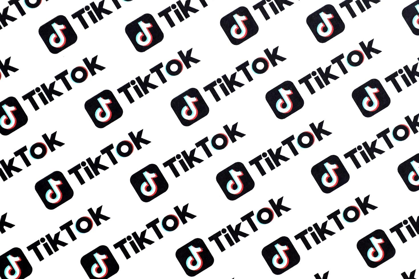 ternopil, ucrania - 2 de mayo de 2022 muchos logotipos de tiktok impresos en papel. tiktok o douyin es un famoso servicio chino de alojamiento de videos de formato corto propiedad de bytedance foto