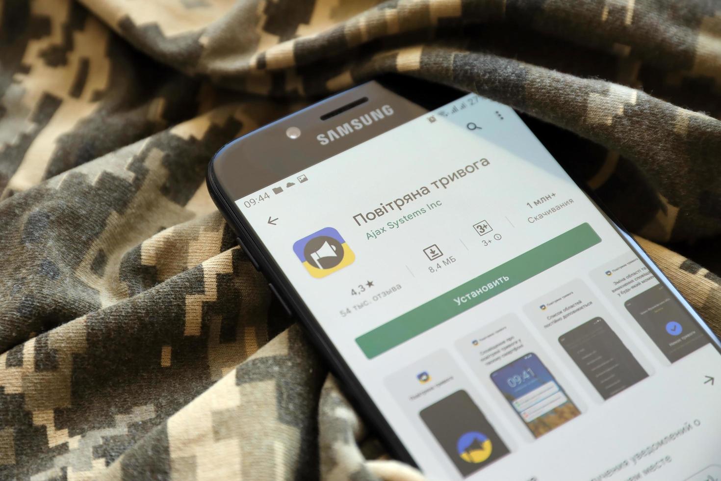 TERNOPIL, UKRAINE - APRIL 24, 2022 Air Raid Siren app for mobile phone on smartphone display screen on the military camouflage photo