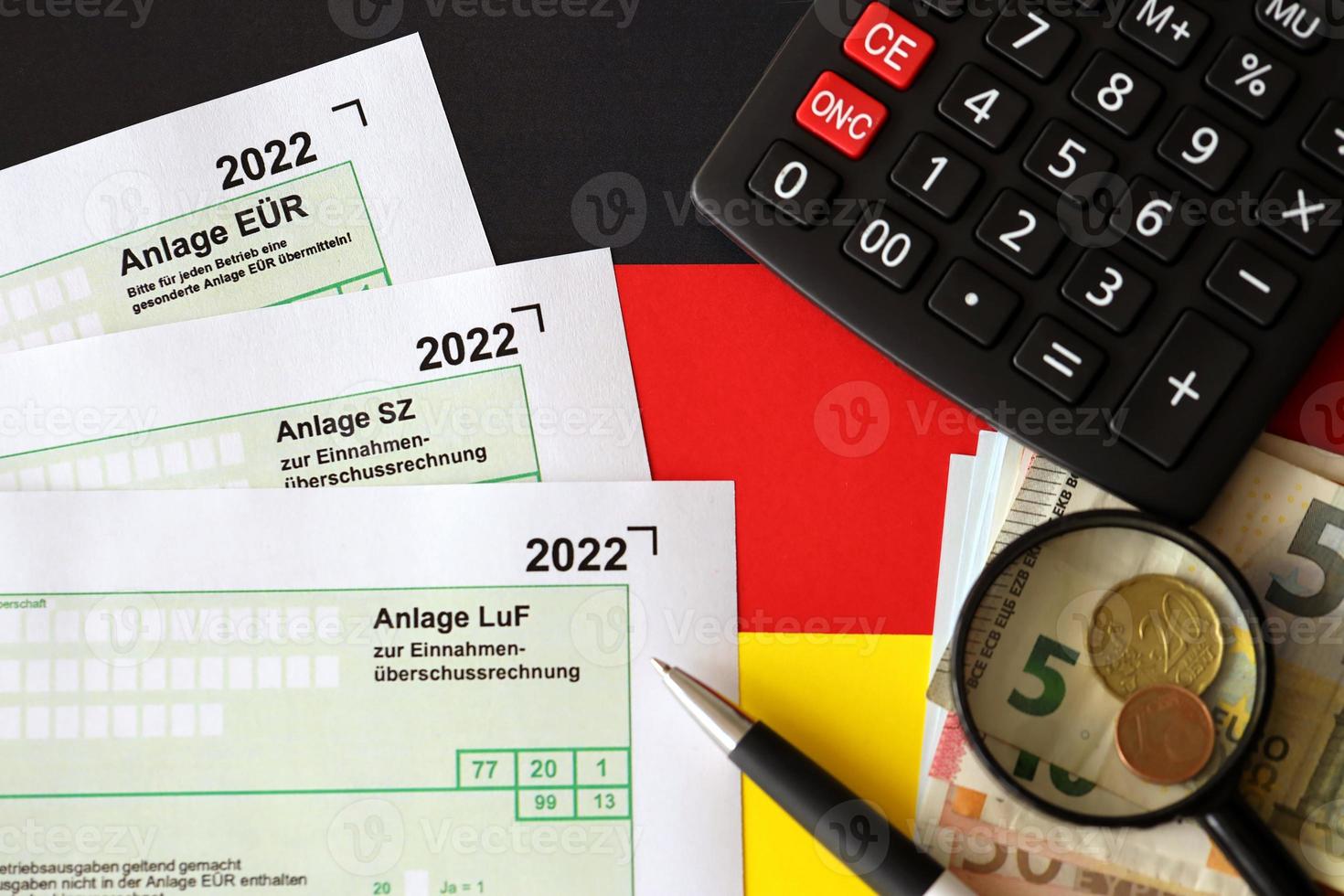 Formularios en blanco de declaración de impuestos diferentes en alemán: anlage eur, anlage sz y anlage luf. los documentos se encuentran con calculadora, bolígrafo y dinero europeo foto