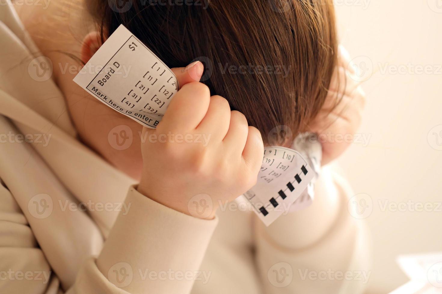 A sad young girl suffers from a loss after looking the unlucky result of the lottery gambling. The concept of losing the lottery and spend money photo