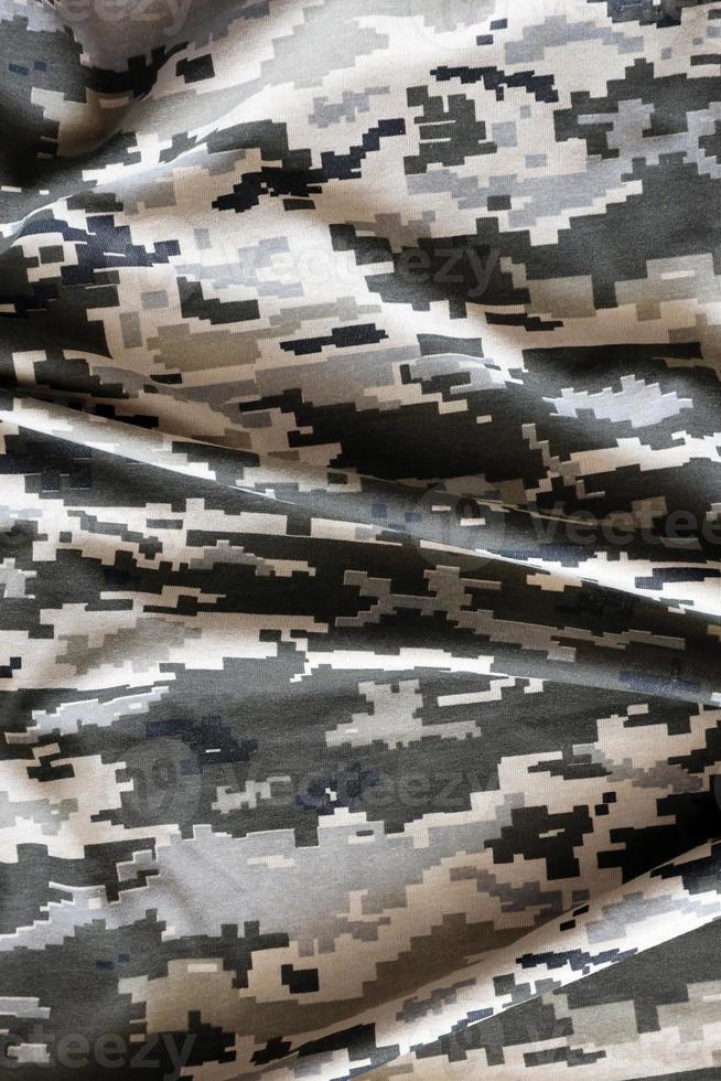 Fabric with texture of Ukrainian military pixeled camouflage. Cloth with camo pattern in grey, brown and green pixel shapes. Official uniform of Ukrainian soldiers photo