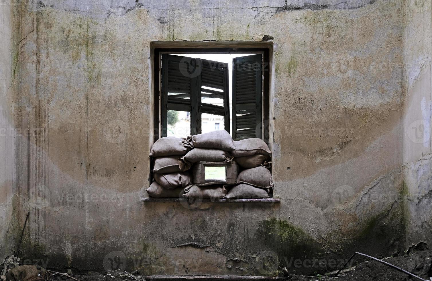 casa abandonada con sacos de arena en la ventana de la línea verde de la zona de amortiguamiento en nicosia, chipre foto